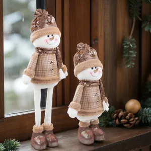 Primo piano di simpatiche bambole di peluche di pupazzo di neve di Natale con abiti a quadri.