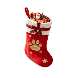 Large Christmas stocking decoration with knit cuff plaid bow and festive mini toys inside tree.