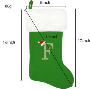 Grüne Weihnachtssocke mit weißer Plüschstulpe und goldenem Glitzerbuchstaben F für Geschenke.