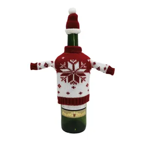 Housse de bouteille de vin tricotée de Noël avec design de pull et bonnet pour déco de fête.