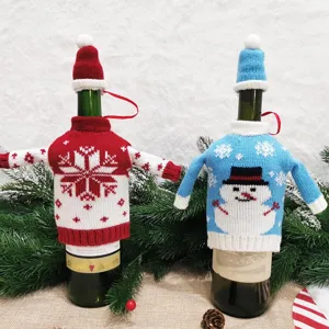 Vue détaillée de housses de bouteille de vin tricotées de Noël aux motifs festifs rouges et bleus.