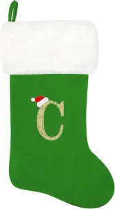 Grüner Weihnachtsstrumpf mit weißem Fell und besticktem goldenem Buchstaben C als Geschenktasche.