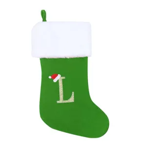 Grüner Weihnachtssocke Detail mit weißem Plüschbündchen und goldenem Stickbuchstaben.