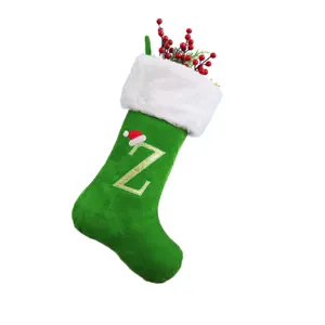 Nahaufnahme des grünen Samt-Weihnachtsstrumpfs mit gesticktem Buchstaben Z und roter Weihnachtsmütze.
