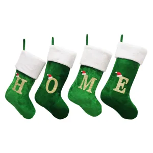 Set aus grünen Samt Weihnachtssocken mit weißem Plüsch und goldenen Buchstaben HOME