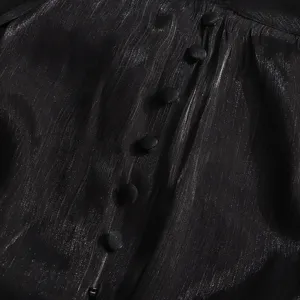 Gros plan sur la robe en tissu métallisé noir montrant des boutons exquis et texture.