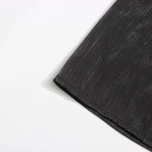 Gros plan détaillé de la robe en tissu fil métallisé noir, texture fine et coutures propres.
