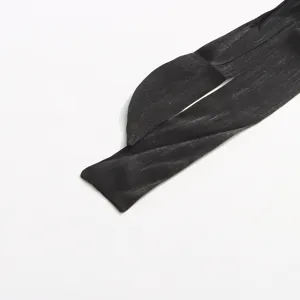 Gros plan détaillé d'une bretelle de robe en soie brillante noire, texture élégante.