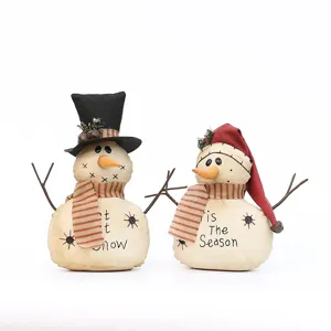 Bambole di peluche di pupazzo di neve in tessuto rustico con sciarpe per decorazioni.