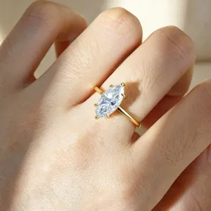 Close-up detail shot of a stunning marquise cut moissanite diamond ring on a golden band.
