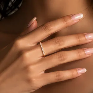 Close-up view of a dainty sterling silver half eternity ring sparkling with tiny clear cubic zirconia.