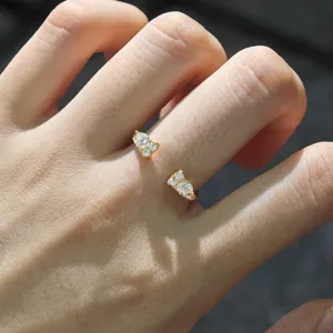 Gros plan de détail de la bague ouverte délicate avec des pierres moissanite étincelantes.