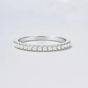 Close-up detail of silver half-pave zircon eternity ring, sparkling gemstone wedding band.