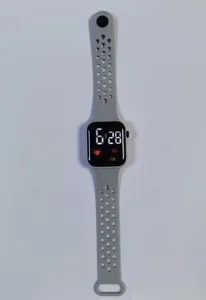 Grey LED digital smartwatch detail shot, featuring a breathable perforated silicone band.