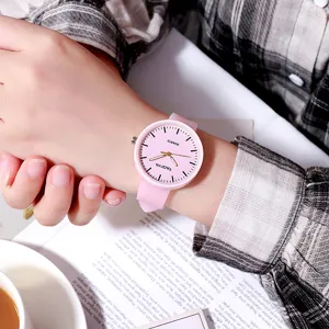 Vista di dettaglio di un grazioso orologio al quarzo rosa con cinturino in silicone al polso.