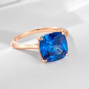 Gros plan détaillé d'une bague en argent plaqué or rose avec zircon coussin bleu.