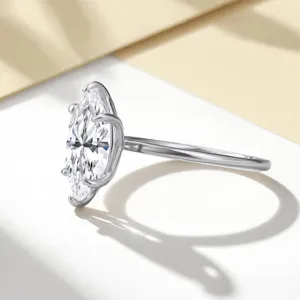 Gros plan d'une bague solitaire en moissanite taille marquise, éclat brillant et anneau fin.