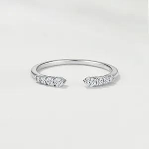 Detailed shot of open silver ring featuring sparkling graduated moissanite stones on both ends.