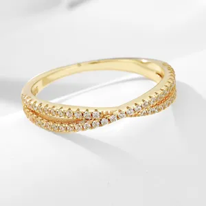 Detailed close-up of gold-plated 925 silver double crossover pavé cubic zirconia ring.