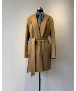 Close-up detail of the elegant camel hooded wool blend coat with belt and pockets.