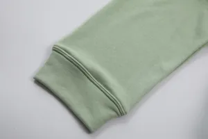 Detailed view of the sage green cotton hoodie cuff, showing fine stitching and soft fabric texture.