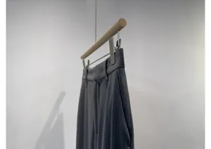 Grey corduroy wide leg trousers detail shot, showing fabric texture and neat hanging form.