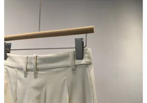 Close-up detail of women's white corduroy trousers waist and belt loops, casual chic style.