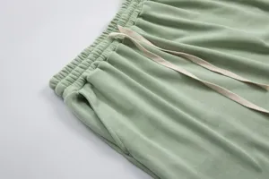 Green cotton casual pants detail showing elastic waistband, adjustable drawstring and pocket.