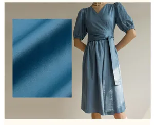 Robe mi-longue bleue à col V et manches bouffantes avec lien de taille et détail.