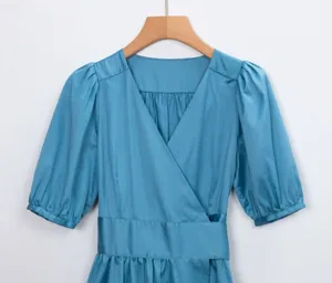 Vue rapprochée détaillée de la texture de la robe portefeuille bleue style français.