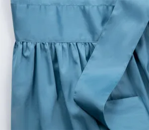 Détail de tissu de robe bleue, plis de taille élégants et ceinture, vêtement style français gros plan.