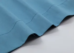 Gros plan sur le tissu en coton bleu de haute qualité avec des coutures soignées sur la robe.