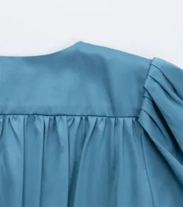 Gros plan sur les plis d'épaule de la robe française bleu-gris à manches bouffantes