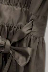 Gros plan sur les details de la taille de la robe avec une elegante ceinture noeud.