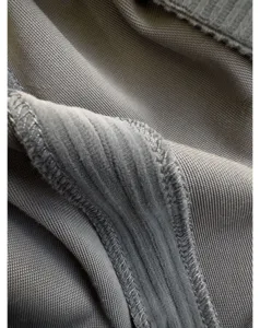 Close-up detail view of grey ribbed corduroy fabric showing fine stitching and soft texture.