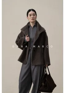 Scatto di dettaglio di un elegante cappotto corto in alpaca marrone con maglia e pantaloni.