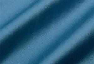 Vue rapprochée de la texture du tissu bleu de première qualité, tombé et brillant doux.