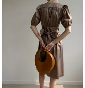Robe midi marron de style français à manches bouffantes, joli nœud au dos et sac chic.