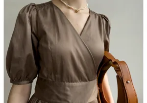 Détail en gros plan de la robe française à manches bouffantes et son col en V élégant.
