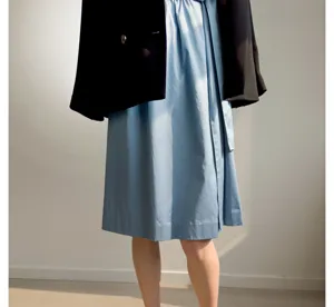 Vue détaillée de la robe en coton bleu avec une veste noire sous un bel éclairage naturel.