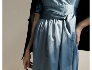 Détail de robe portefeuille en satin élégante avec ceinture large et manches bouffantes.
