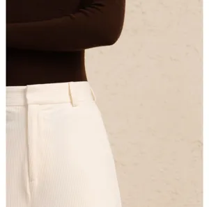Women's corduroy pants detail shot, high waist straight leg casual trousers in creamy white color.