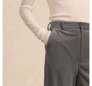 Corduroy trousers detail view showcasing fabric texture, pocket construction and belt loops.