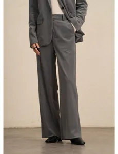Detail view of women's dark grey corduroy wide-leg trousers and matching suit jacket.