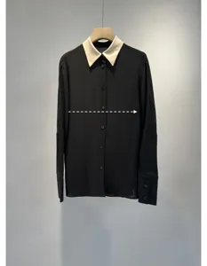 Detailed close-up view of the elegant black long sleeve shirt featuring a contrast white collar.