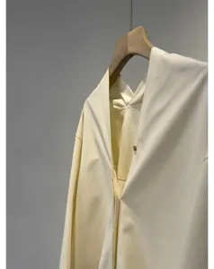 Detailed view of cream white cotton poplin blouse featuring a stylish V-back and wide sleeves.
