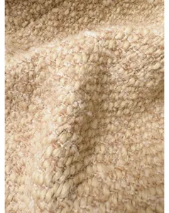 Close-up van beige getextureerde tweed stof met zachte wolgeweven details en fijne feel.