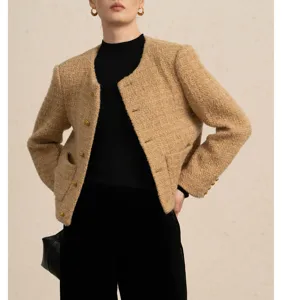 Detailopname van een chique korte tweed jas met gouden knopen en een elegante ronde hals.