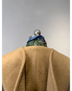 Camel wool hooded coat detail view, classic camel hair textured fabric shoulder design.