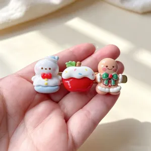 Détail de la jolie pince à cheveux de Noël avec des pendentifs bonhomme de neige et pain d'épices.
